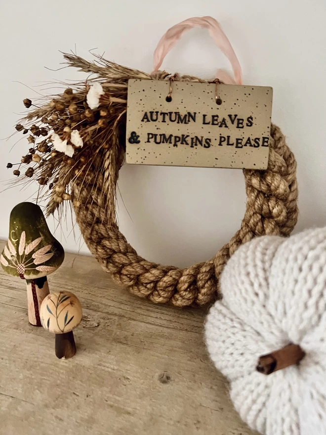 woven knot wreath with a ceramic sign hung over the top