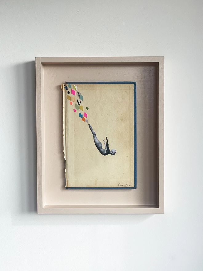 A female swimmer performs the perfect swan dive into the swimming pool below. A framed collage made with vintage papers and pops of neon pink with torn edges and interesting textures.