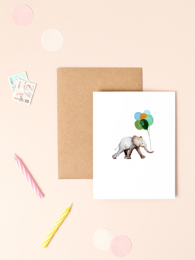 A charming illustration of a joyful elephant holding a cluster of colorful balloons, exuding a sense of celebration and happiness. The elephant's playful stance and the vibrant hues of the balloons create a whimsical and festive atmosphere. The minimalist design and soft background enhance the cheerful mood, making this mini card a delightful choice for birthdays, congratulations, or any occasion that calls for a touch of joy.