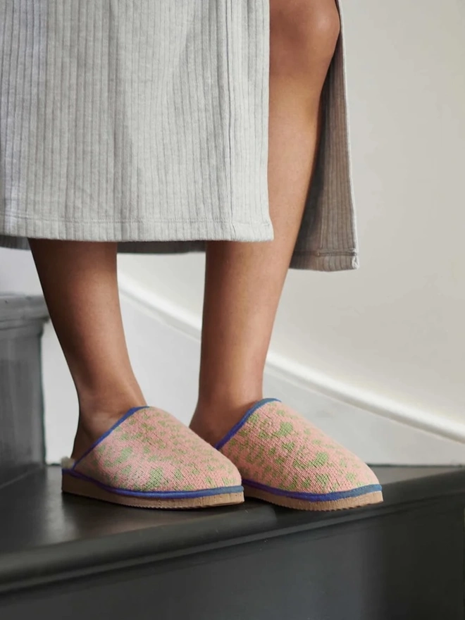 Women's Lambswool & Sheepskin Slippers, a person wearing a pair of colourful slippers indoors. 