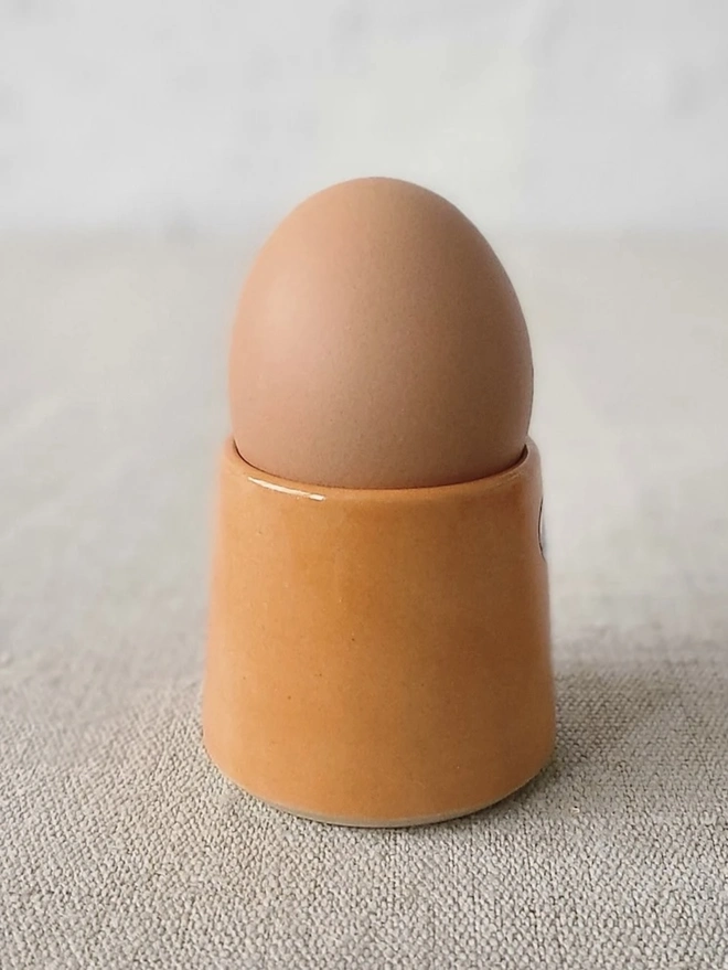 Classic Handmade Egg Cup, a ceramic egg cup sitting on a carpet surface against a grey backdrop. 