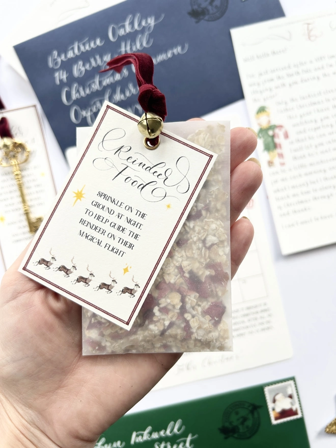 Reindeer food made from oats and dried petals in glassine bag with red velvet ribbon and gold bell and poem label