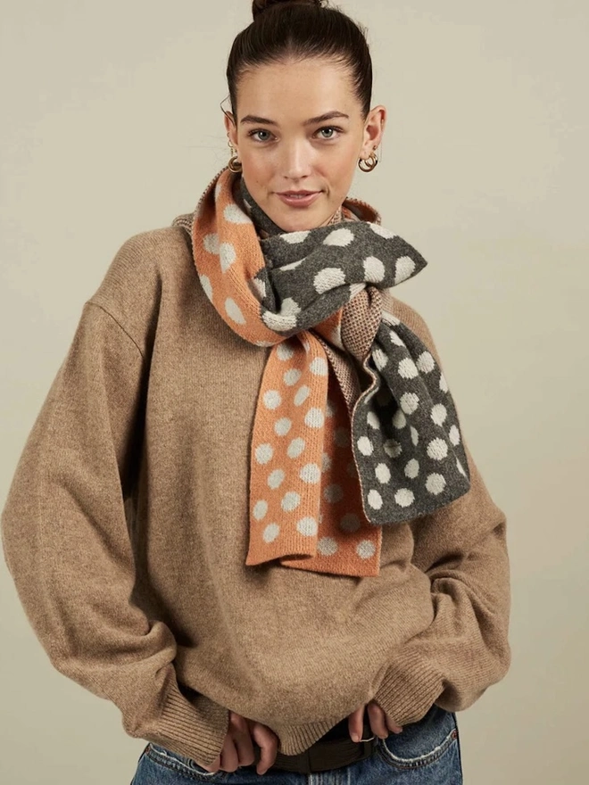 Lambswool Striped Scarf, a woman wearing a colourful striped scarf indoors. 