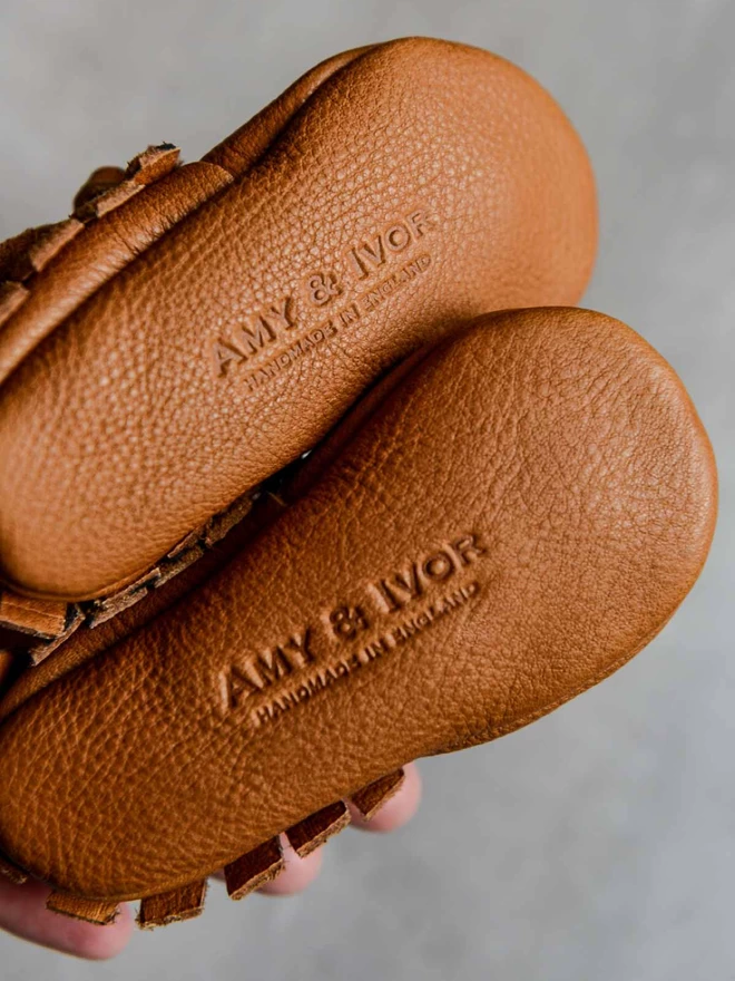 A view of the logo on the soft leather soles of Amy and Ivor baby moccasins