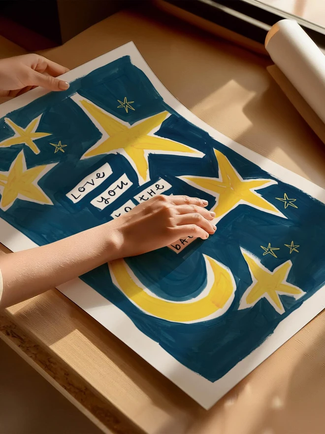 'love you to the moon and back' print. an art print with a blue background, yellow moons and stars and a slogan.