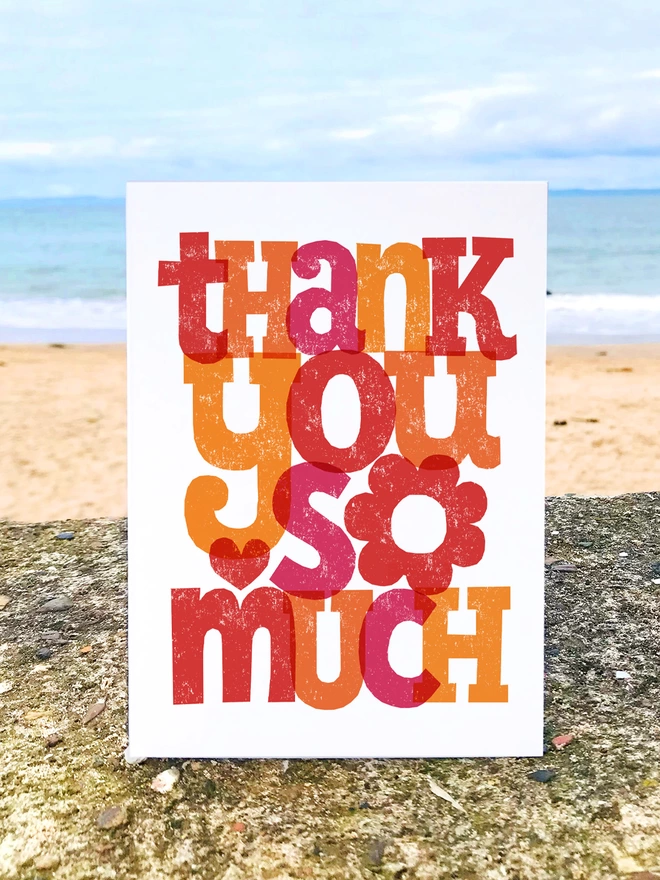 hand lettered thank you so much card on a wall at the beach