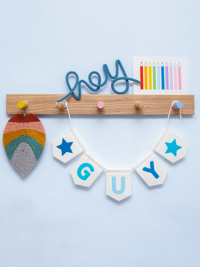 Personalised childrens bunting. The text is a mix of blue tones on white felt flags.