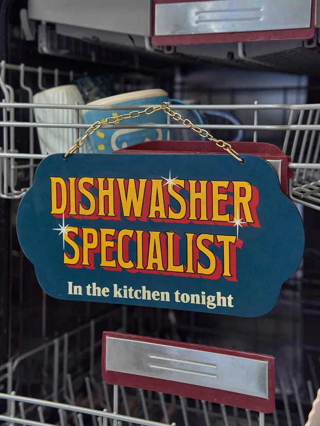 Dishwasher specialist hanging sign gold chain navy background with yellow and red writing 