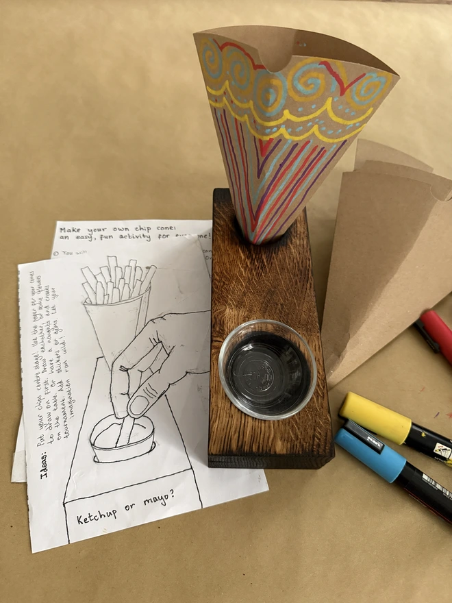 Decorated brown cardboard cones in holder with guide how to make a cone and felt tips