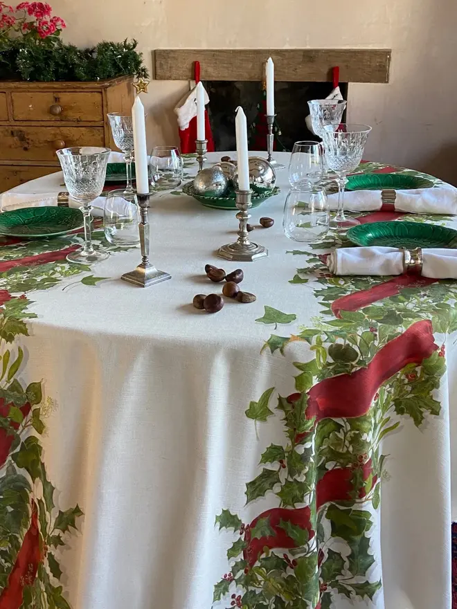 christmas double garland tablecloth. a white table cloth with two painted christmas garlands on a table.
