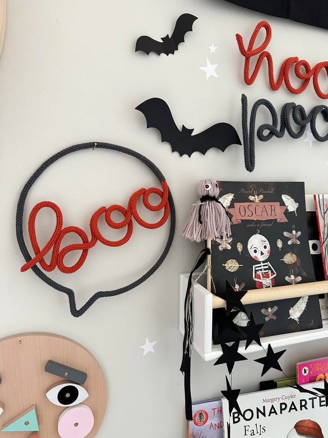 'boo' speech bubble sign hanging on the wall on a stylish kid's bedroom wall.