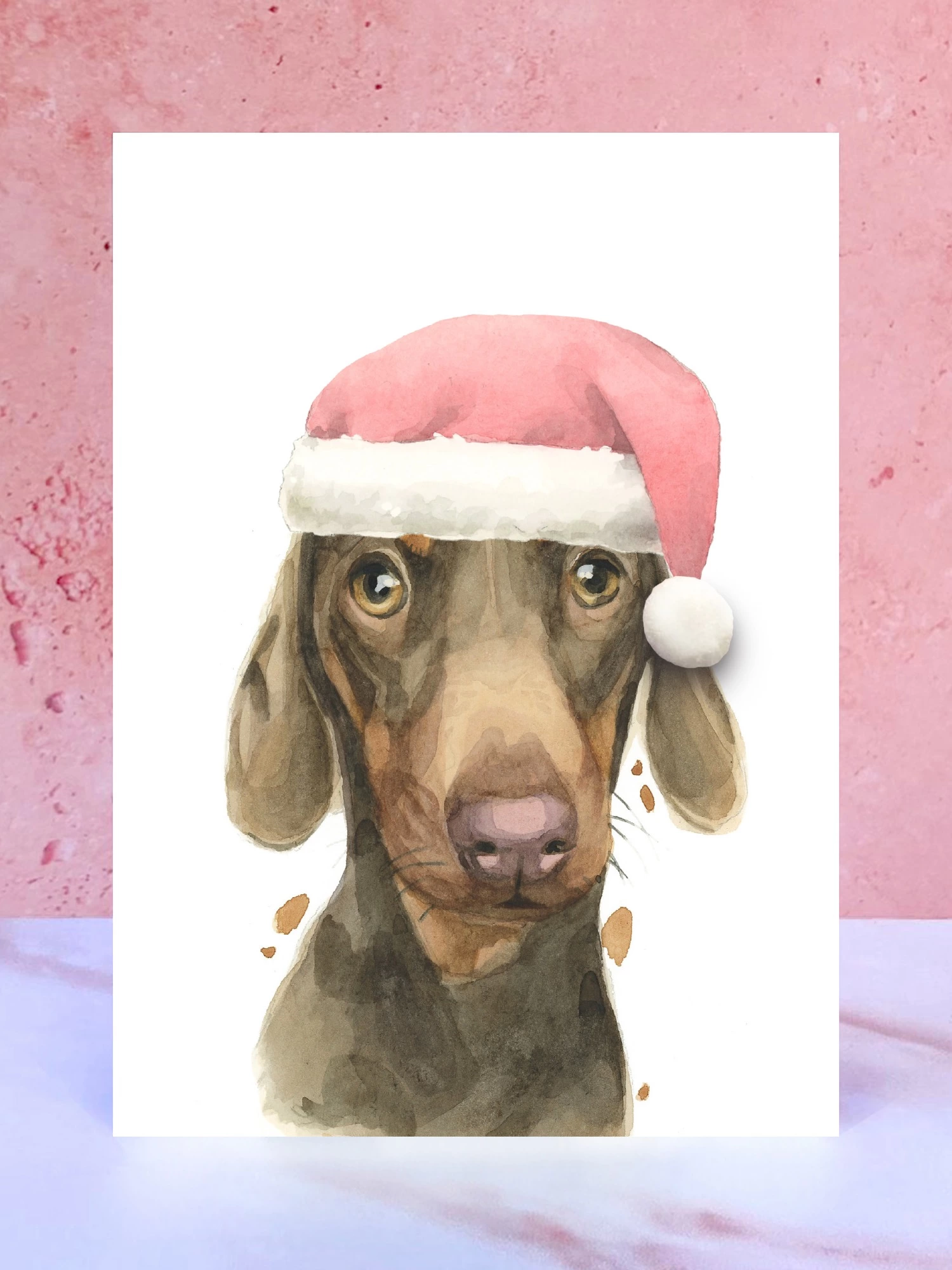 A Christmas card featuring a hand painted design of a dachshund, stood upright on a marble surface.