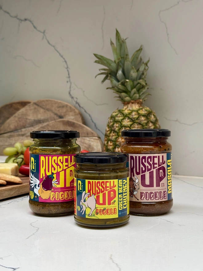 father's day pickles - cheese set. a set of three jars of pickle photographed on a countertop.