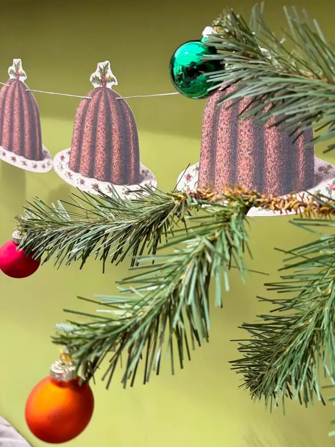 Paper cut out Christmas puddings strung as bunting