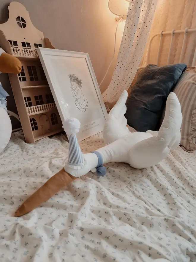 Circus Swan Hanging Decoration, a swan decoration on a bed in a child's room. 