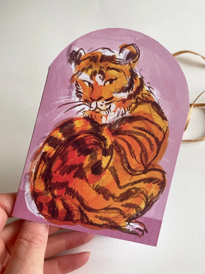 Esther kent illustrated arch-shaped greetings card, showing brown and orange tiger on a pink background