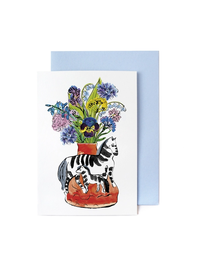 A greeting card featuring a zebra mother & child and flower bouquet