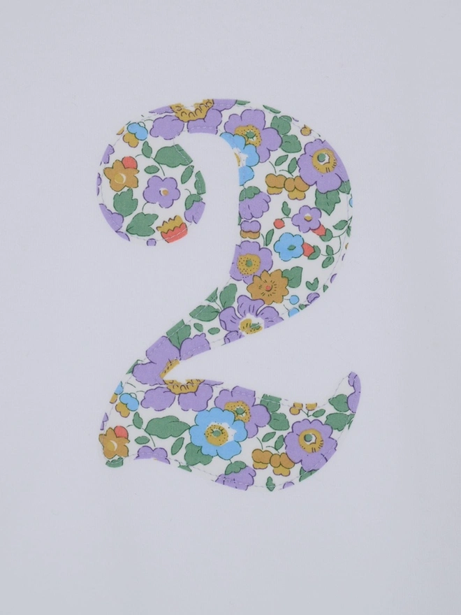 A close up of a Magnificent Stanley kids birthday  Number 2 White T-Shirt in Betsy Purple Liberty Print