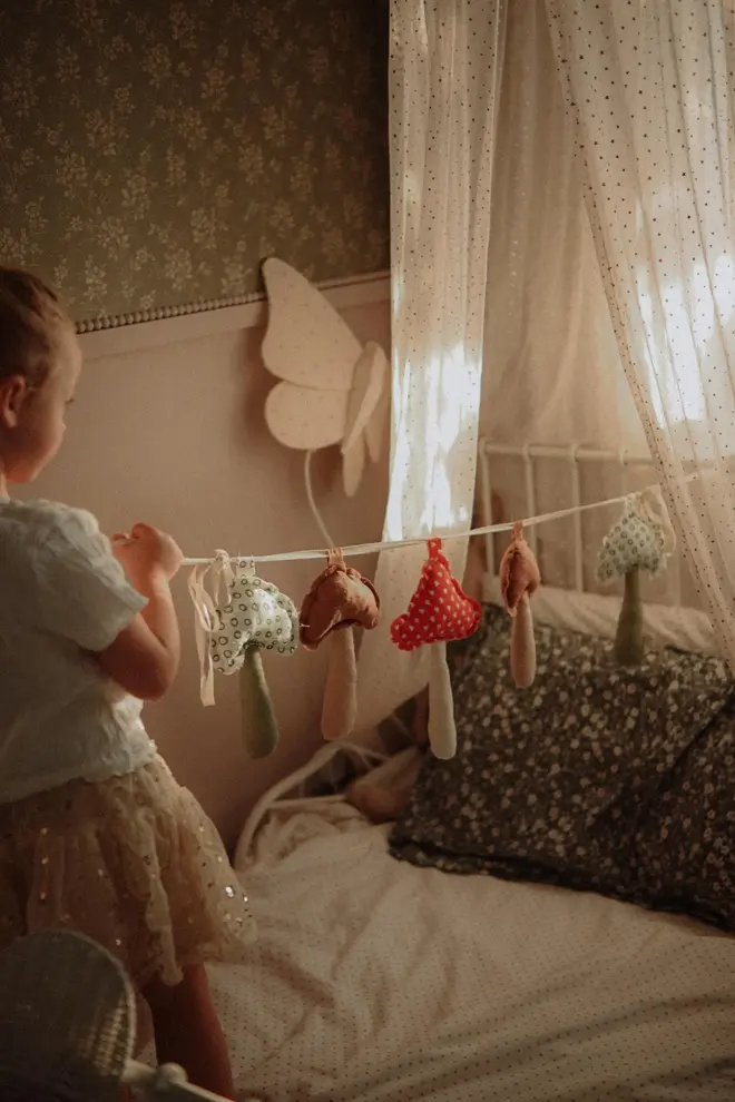 Mushroom Garland Decoration, a child playing with their hanging mushroom bunting in their bedroom.    