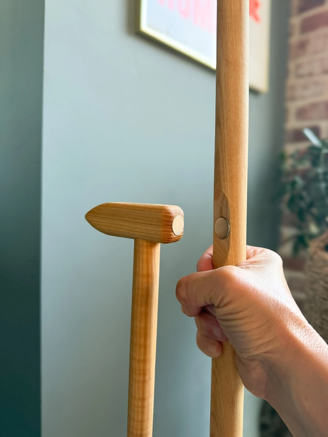 Detail of the T-shaped handle top and magnetic clip holding broom and pan together