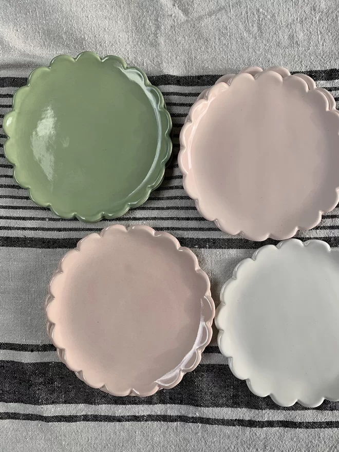 top view of camellia scalloped edge side plates in sage green, pale pink and white