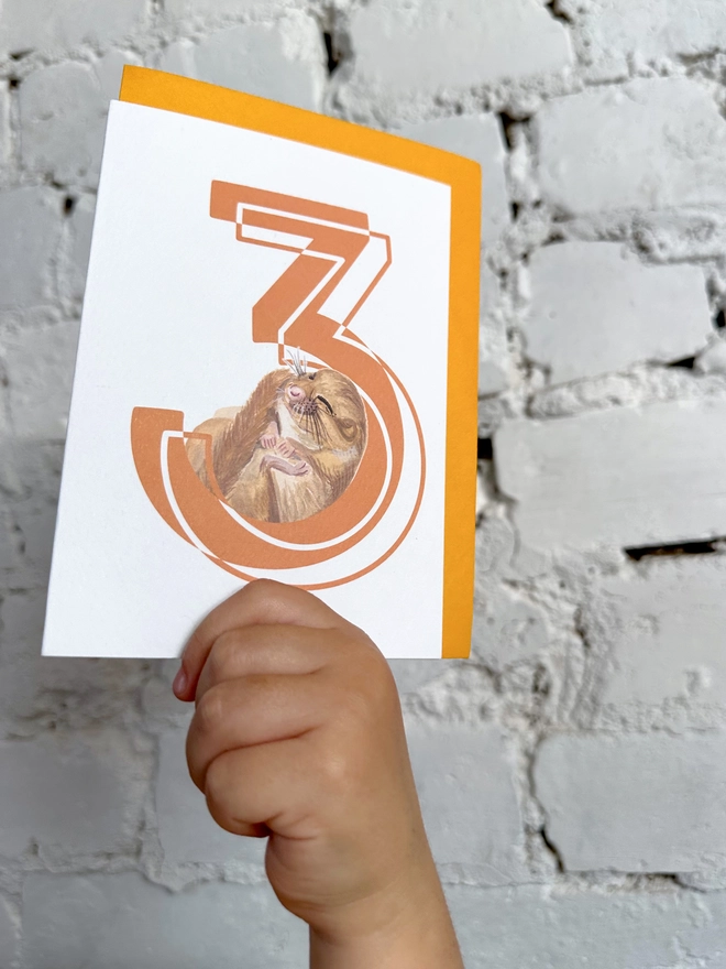 a white card with a big orange number 3 and an illustrated dormouse with a bright yellow envelope