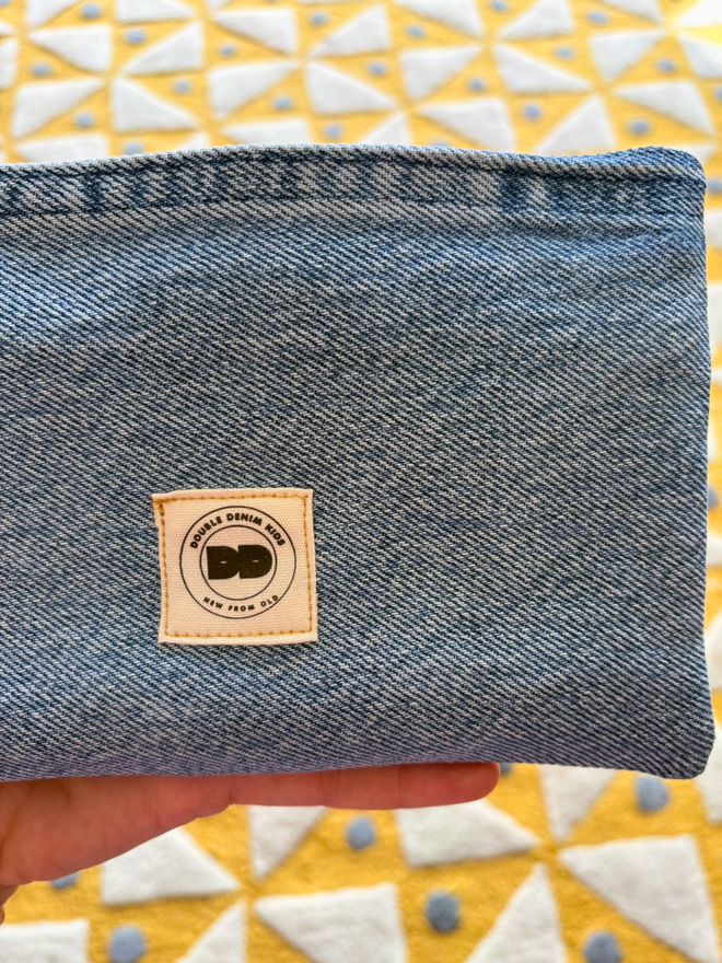 Handmade pencil case made from reclaimed denim with a zip fastening and a bright vintage‑print initial on the front