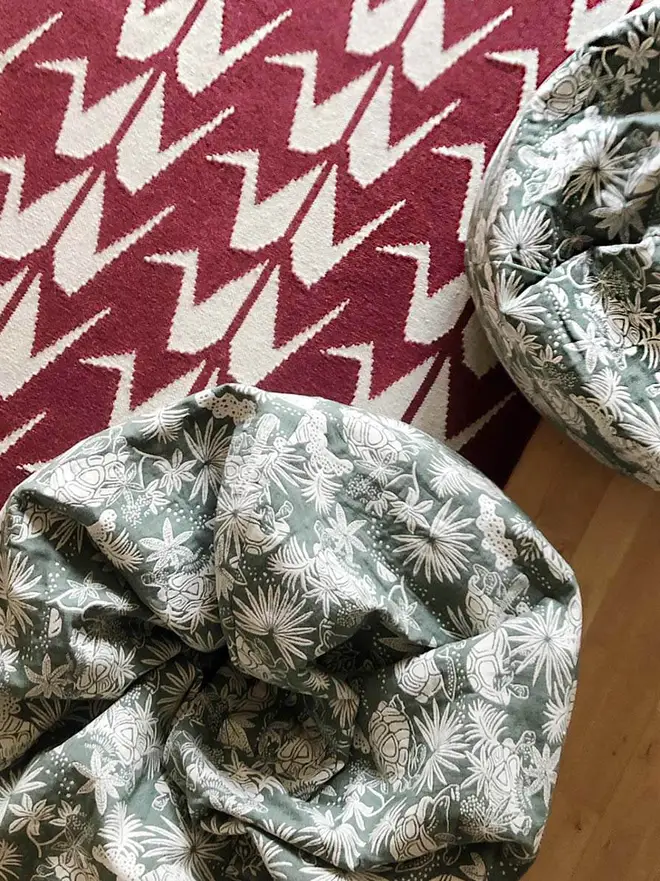 Crane Flatweave Rug, a colourful rug sitting in a living room. It is accompanied by other colourful items. 