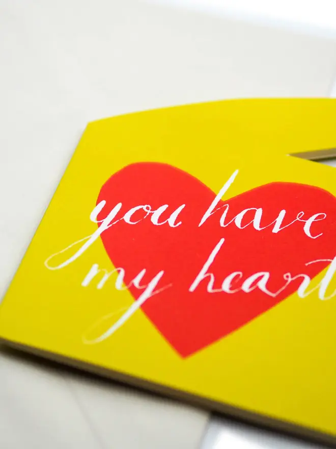 yellow hand shaped card with red heart