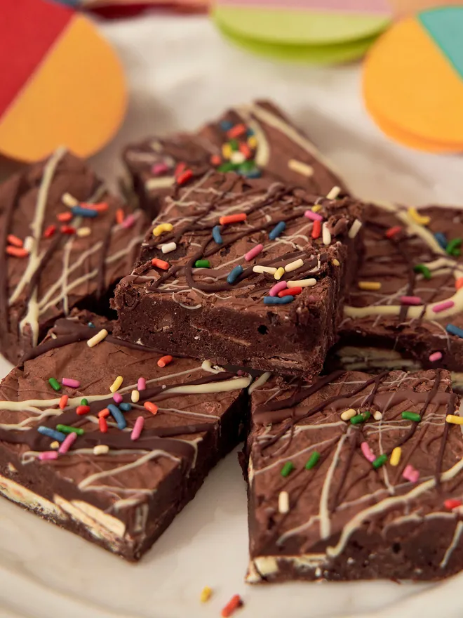 Birthday Brownies - triple chocolate with multicoloured sprinkles on a white plate and colourful bunting