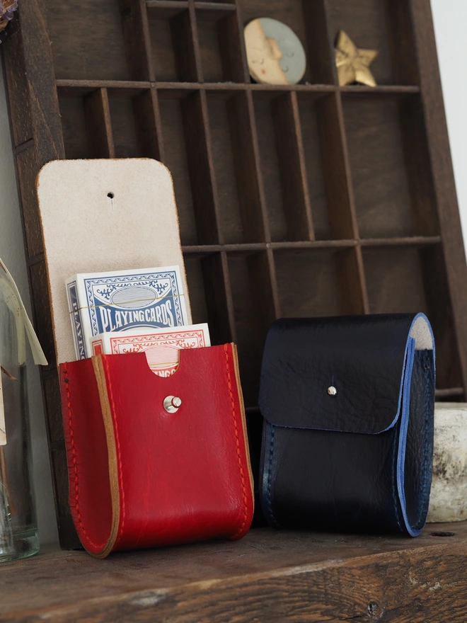 Handmade Leather Double Deck Playing Card Holder. Hand dyed red and dark blue leather pouches carrying two brand new packs of playing cards.