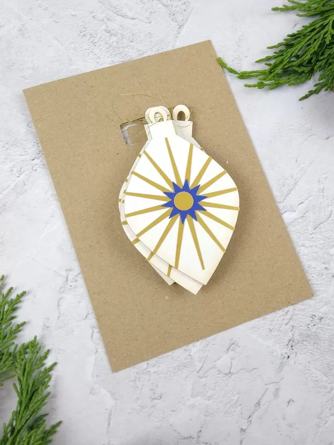Gold Starburst Pendant Paper Christmas Decorations packaged on A6 kraft card backing sheet.