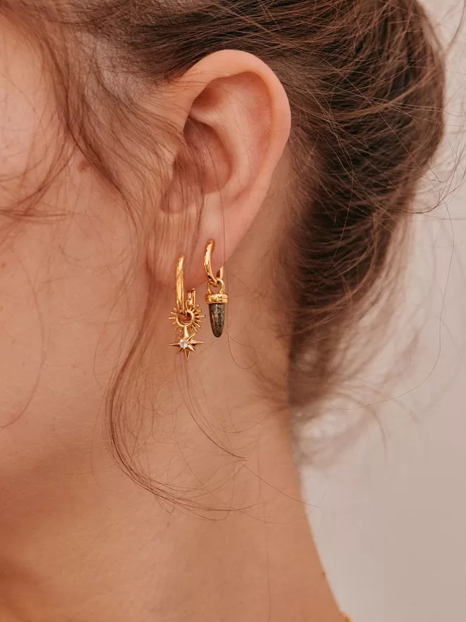 woman wearing gold earrings with charms