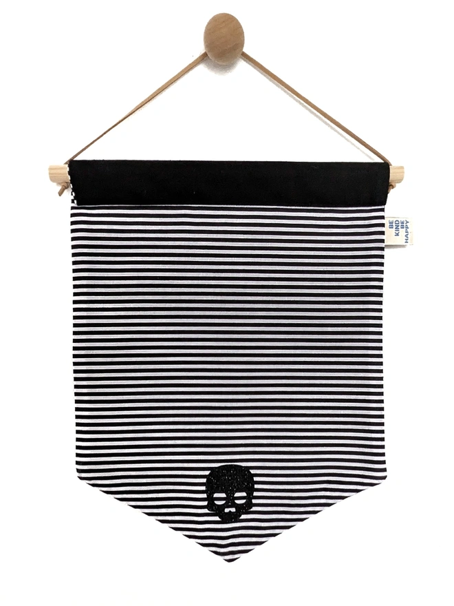 Wednesday inspired backing of the "Enter at Your Own Risk" banner. Black and white stripes. Black and silver text. 