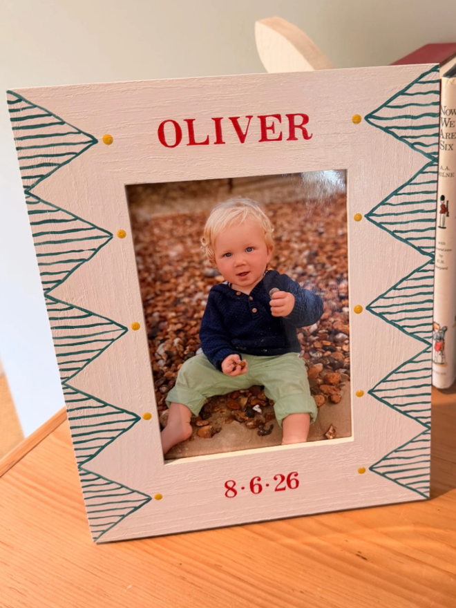 Green Personalised Hand-Painted Geometric Photo Frame. A white photo frame with green geometric patterns.