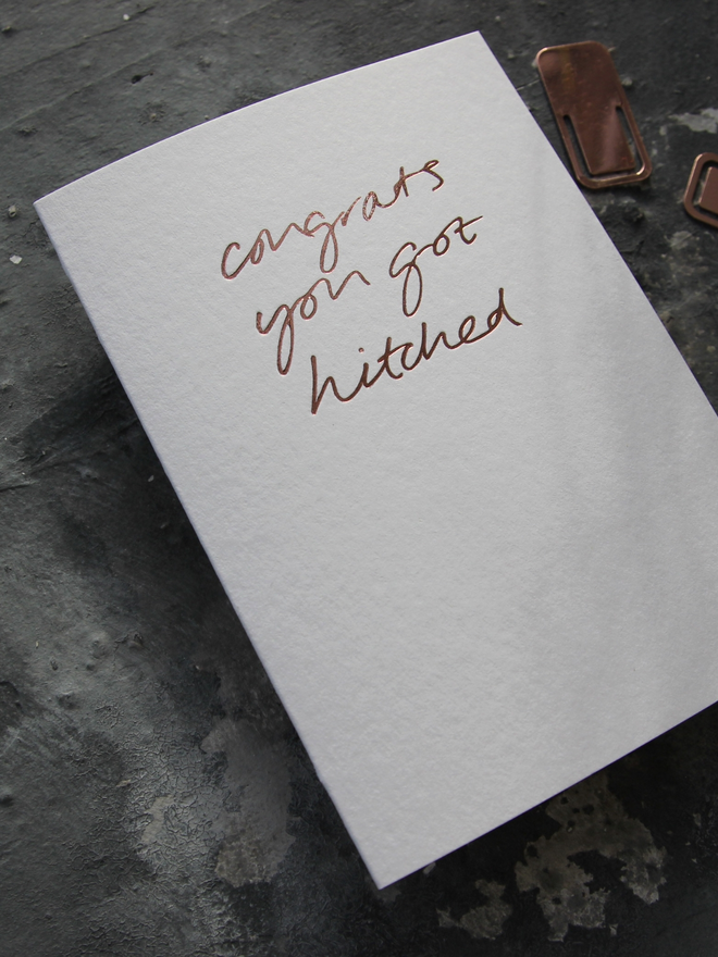 hand foiled card with a handwritten phrase that says Congrats You Got Hitched