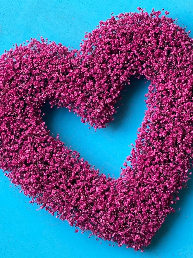 Heart shaped dried flower wreath. Dried pale flowers arranged in a heart shape and made into a wreath.