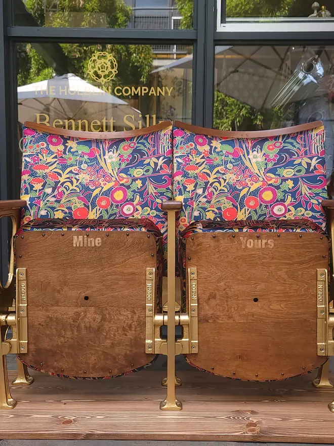 Vintage cinema seats with seats flipped up in front of a showroom window