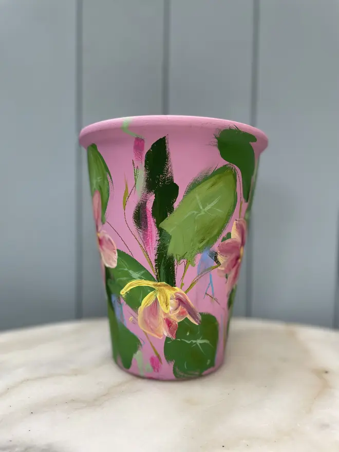 Unique hand-painted terracotta pot featuring pink Nasturtium on a pink background