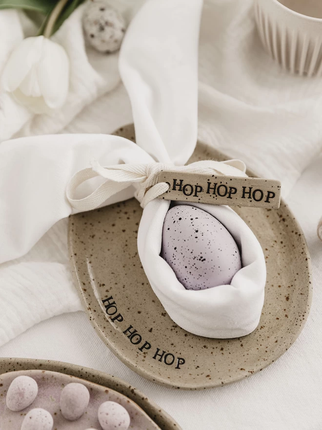 ceramic egg shaped plate with the words 'hop hop hop' around the edge