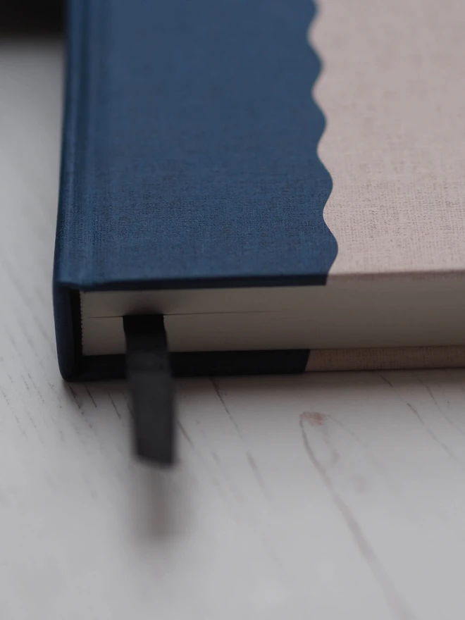 a close up shot of a hardcover linen journal with a black bookmark