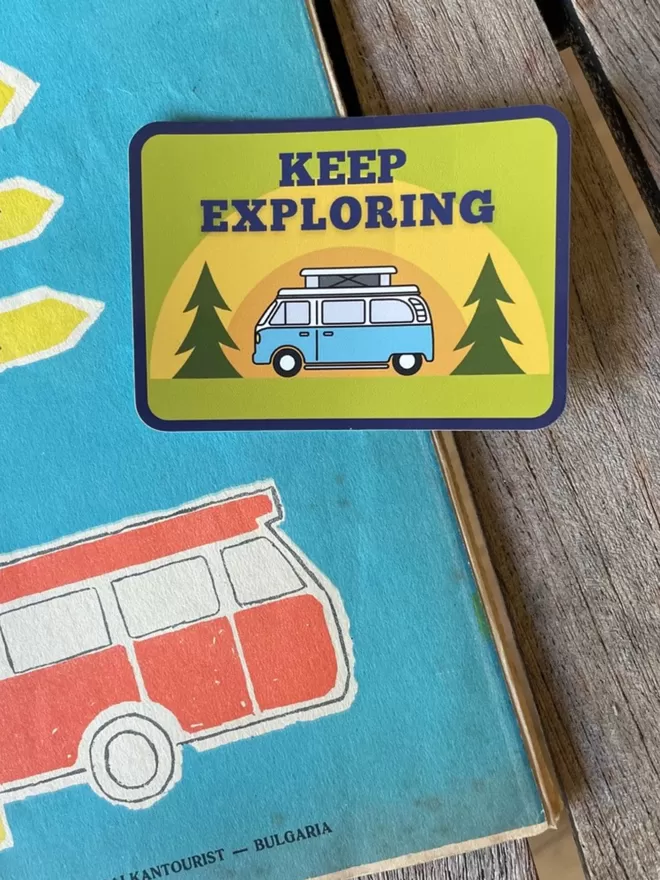 Keep Exploring Vinyl Campervan Sticker laying on a vintage map