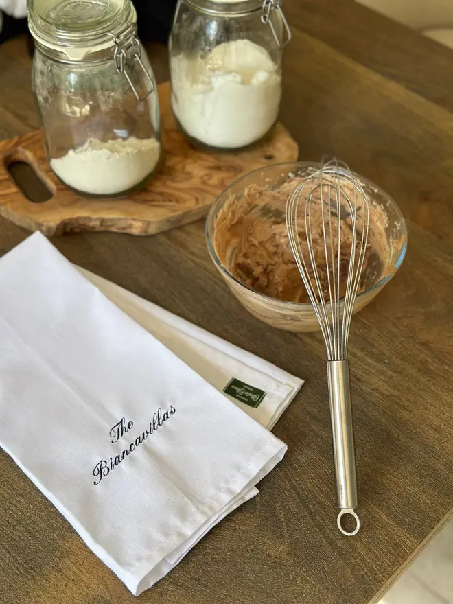 white tea towel on table with cooking untensils