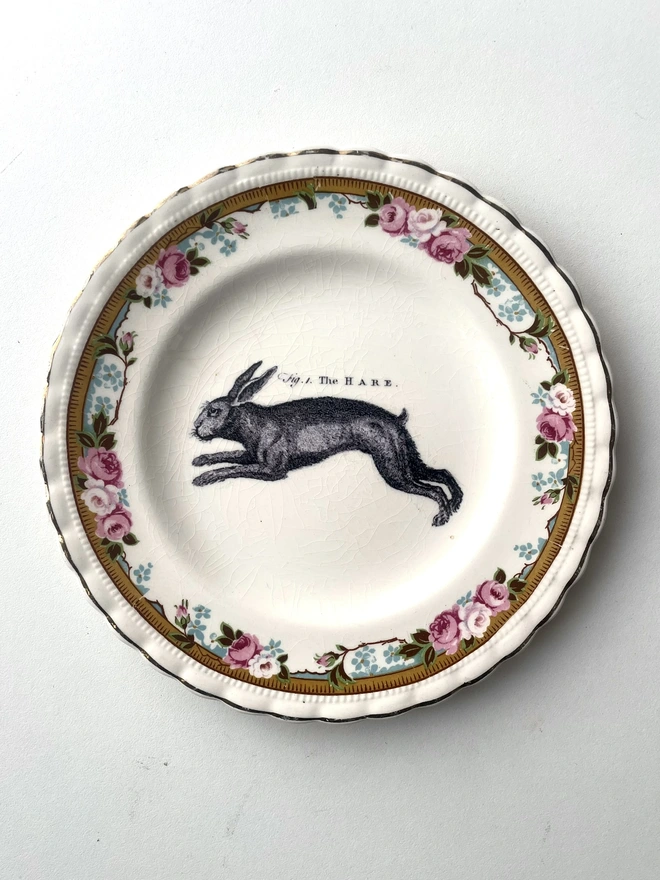 a vintage plate with decorative ornate border of patterns and flowers, in the centre i have printed a vintage black and white illustration of a hare