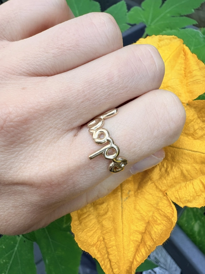 Ring on the index finger which says 'Hope' within it, in 9ct gold