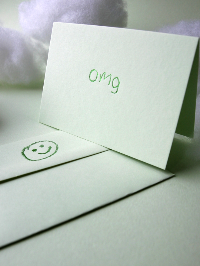 pistachio coloured card with omg short for 'oh my god' hand foiled in kids hand writing
