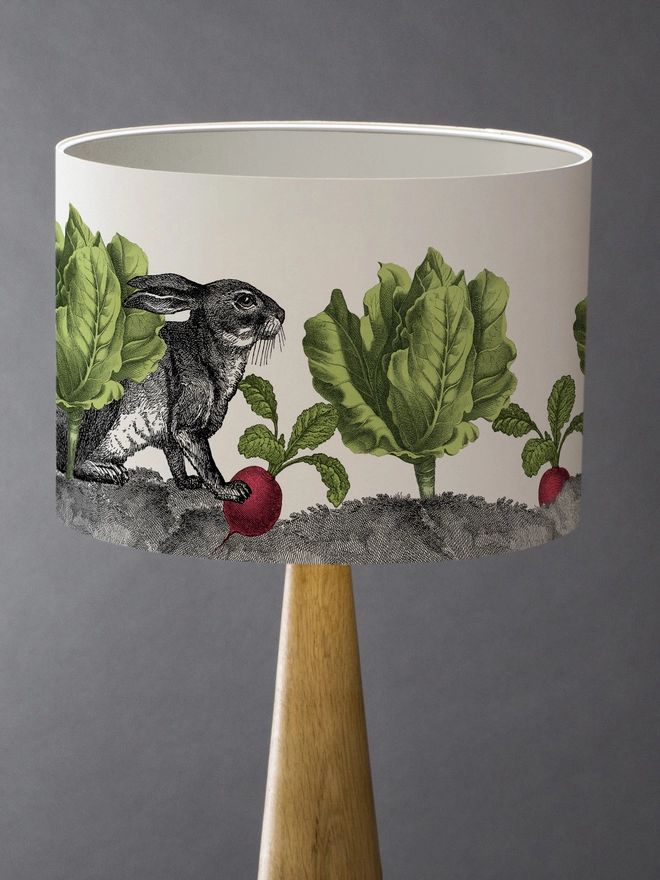 Mischievous rabbit lampshade handmade with vintage animal etchings, hiding among lettuces and radishes in a quirky country-style design. 