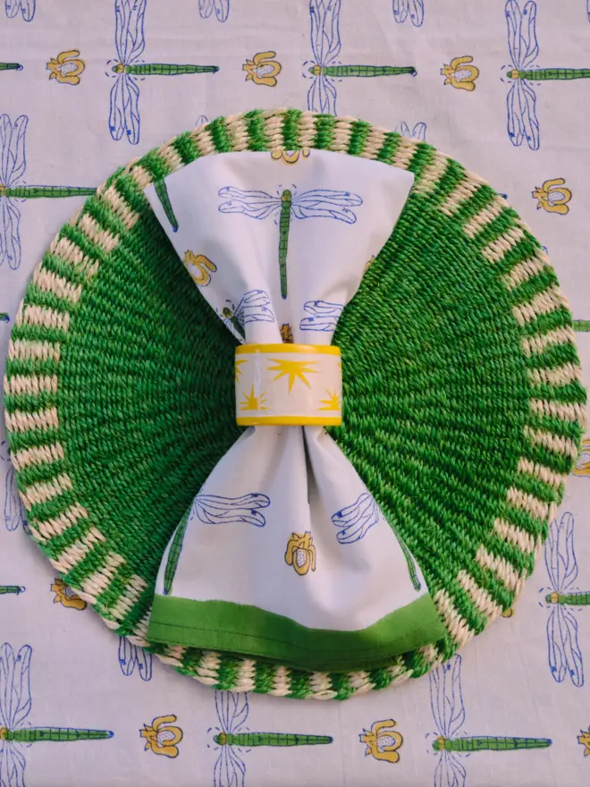 Green placemat sitting on a patterned tablecloth