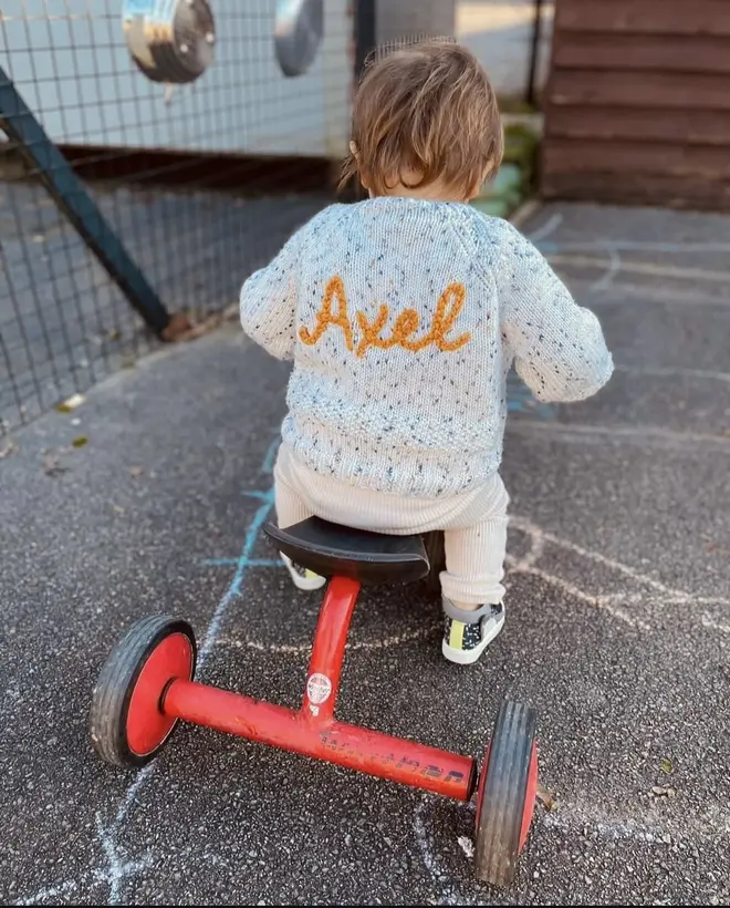 Personalised Cardigans, a young child riding a bike outside wearing a personalised cardigan. 