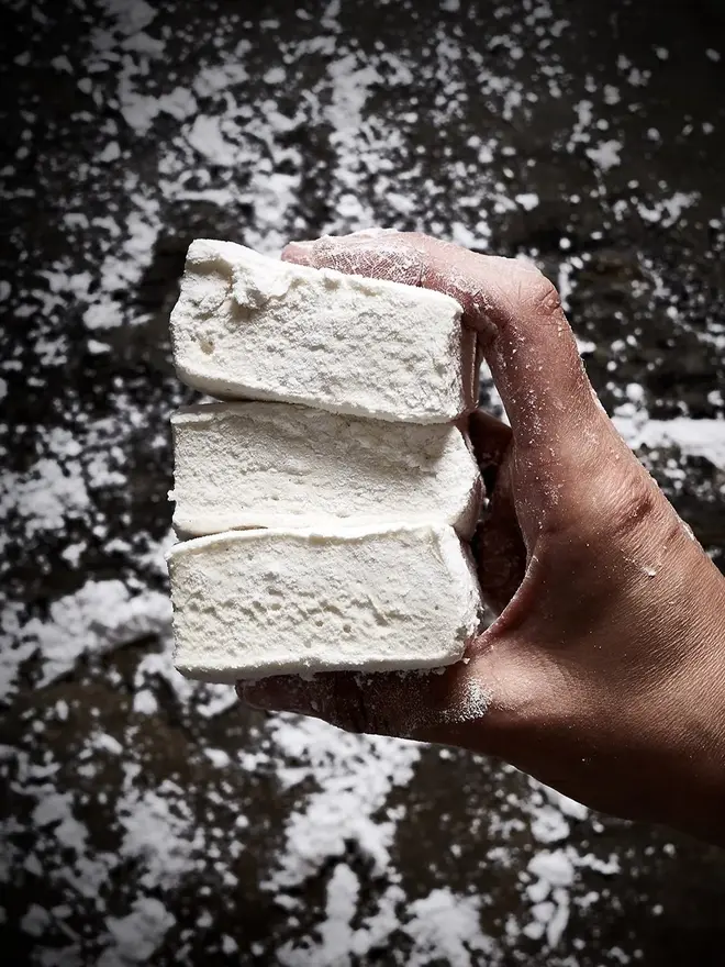 Vanilla Bean Jumbo Mallows (Pack Of 4), three marshmallows stacked on top of each other above a stone surface. 